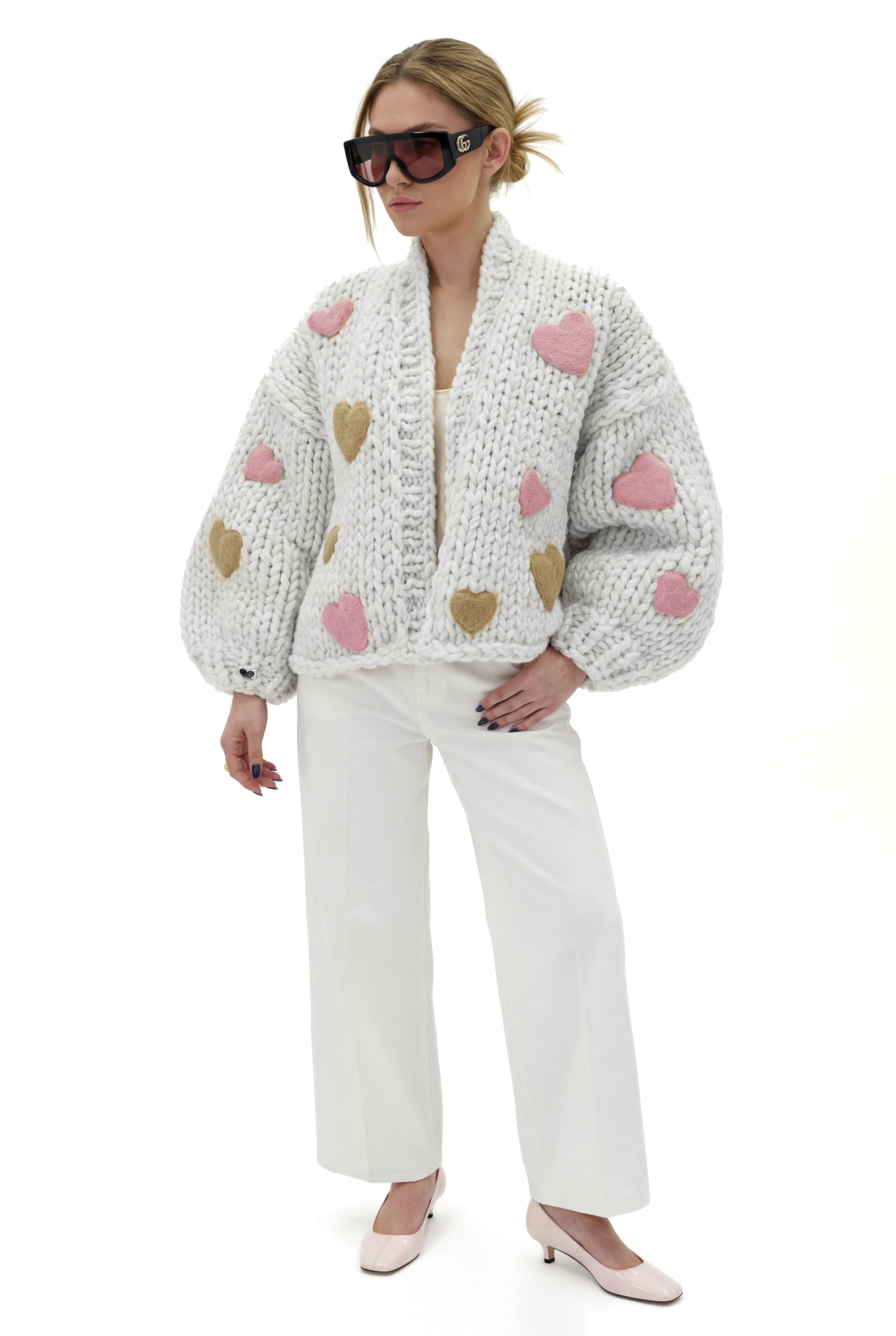 Woman wearing a knitted cardigan with heart patterns. Luxury cardigan